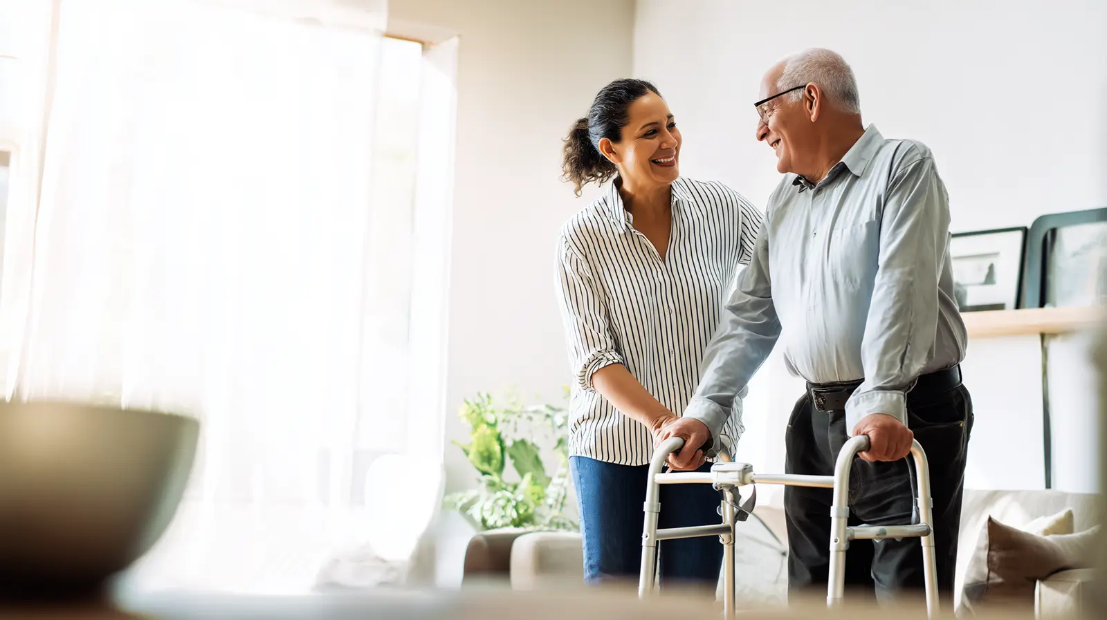 Caregiver helping senior with walker during respite care